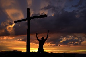 Dramatic sky scenery with a mountain cross and a worshiper by Creative Images (DollarPhotoClub.com)